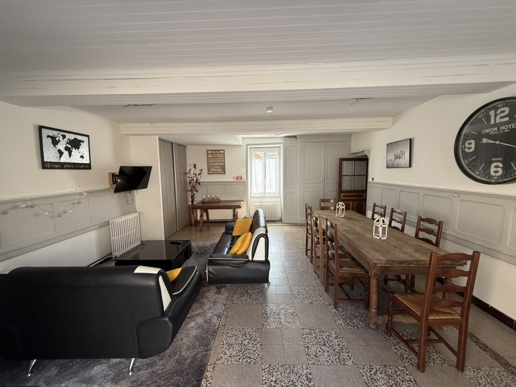 Grand séjour avec une longue table à manger et un espace salon